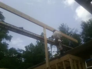 Carpenter setting a ridge beam over a new addition frame — Ice Dam Removal by Roofing Brothers in Carson