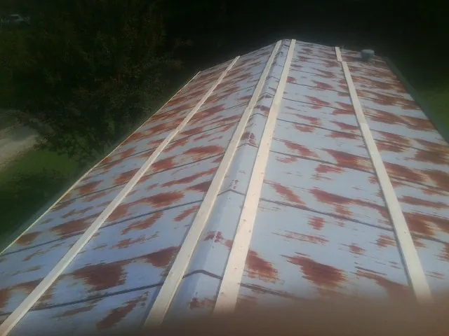 Rusted metal roof panels with new wood purlins before replacement — Storm Damage Roof Repair in Carson by Roofing Brothers